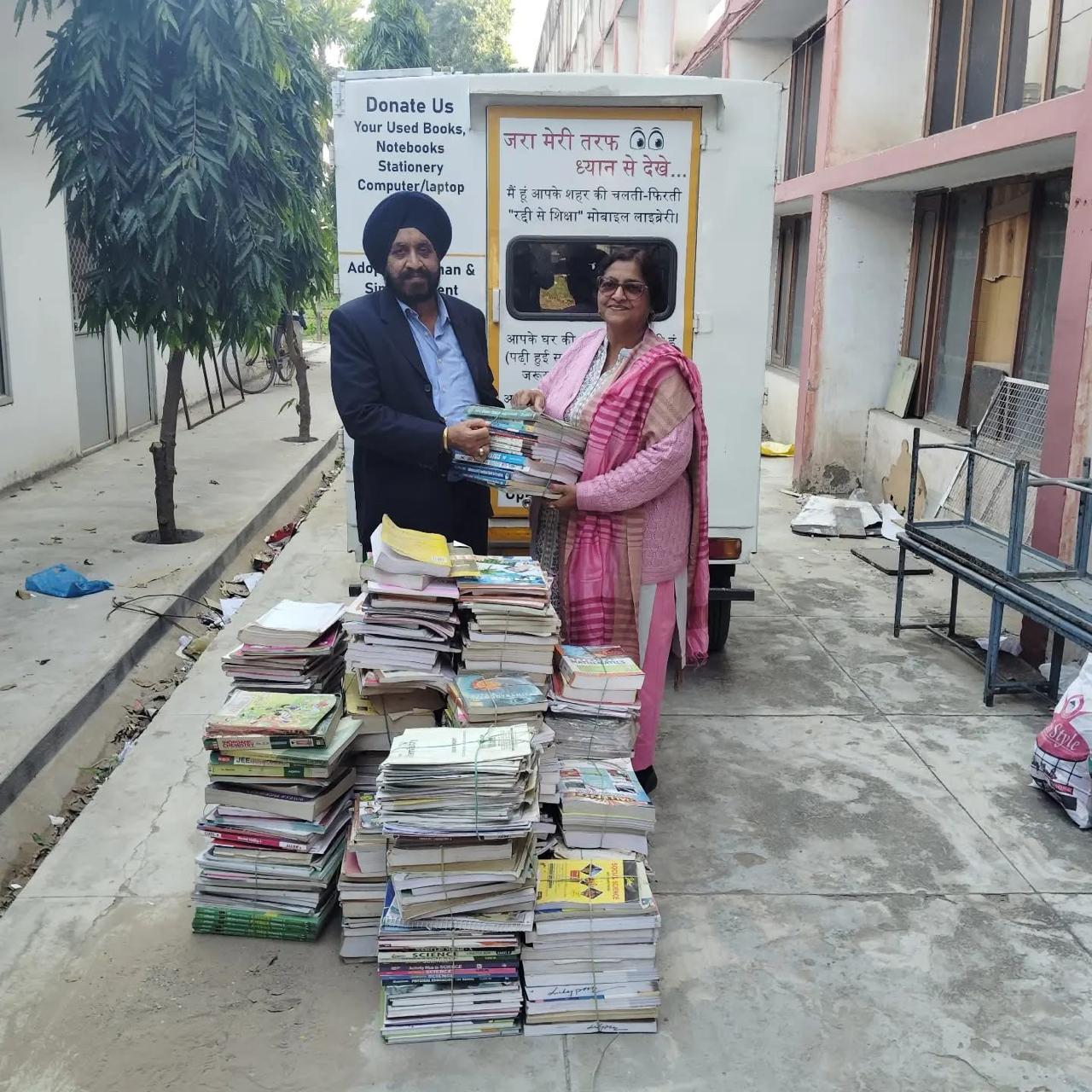 Donors presenting collected books beside a book donation van